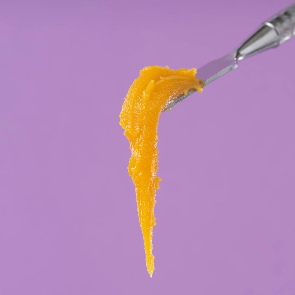 a spoon with a spoon full of orange icing