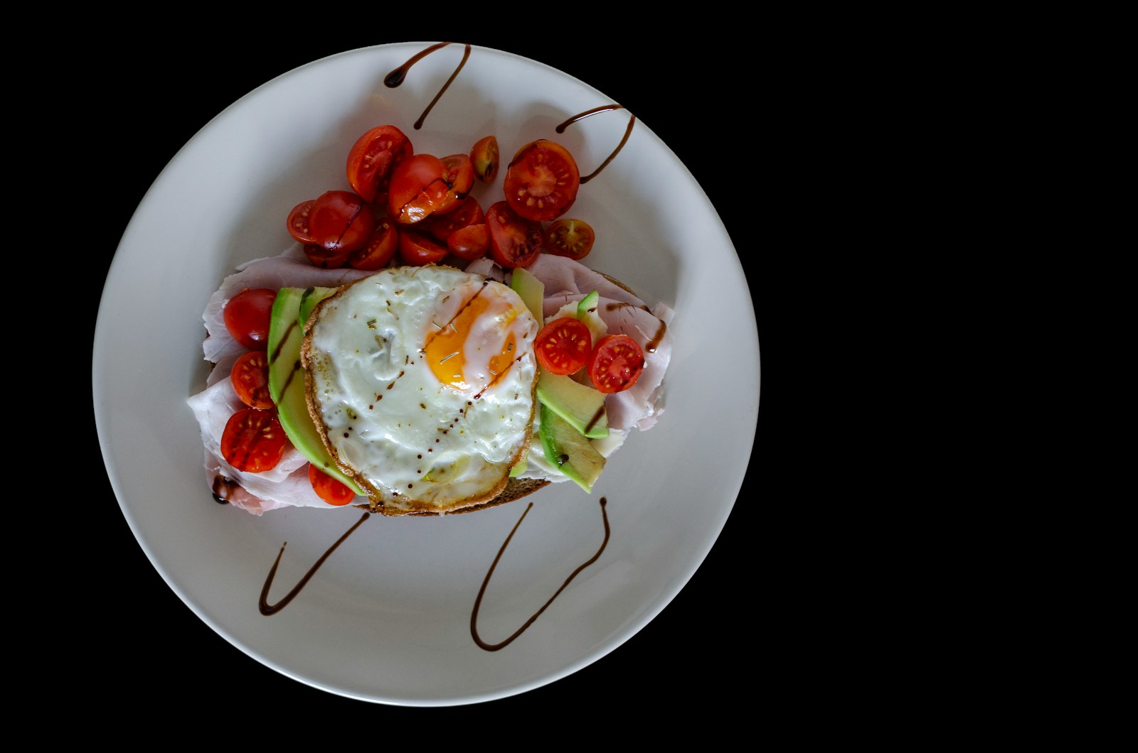 sliced tomato and green leaf vegetable on white ceramic plate